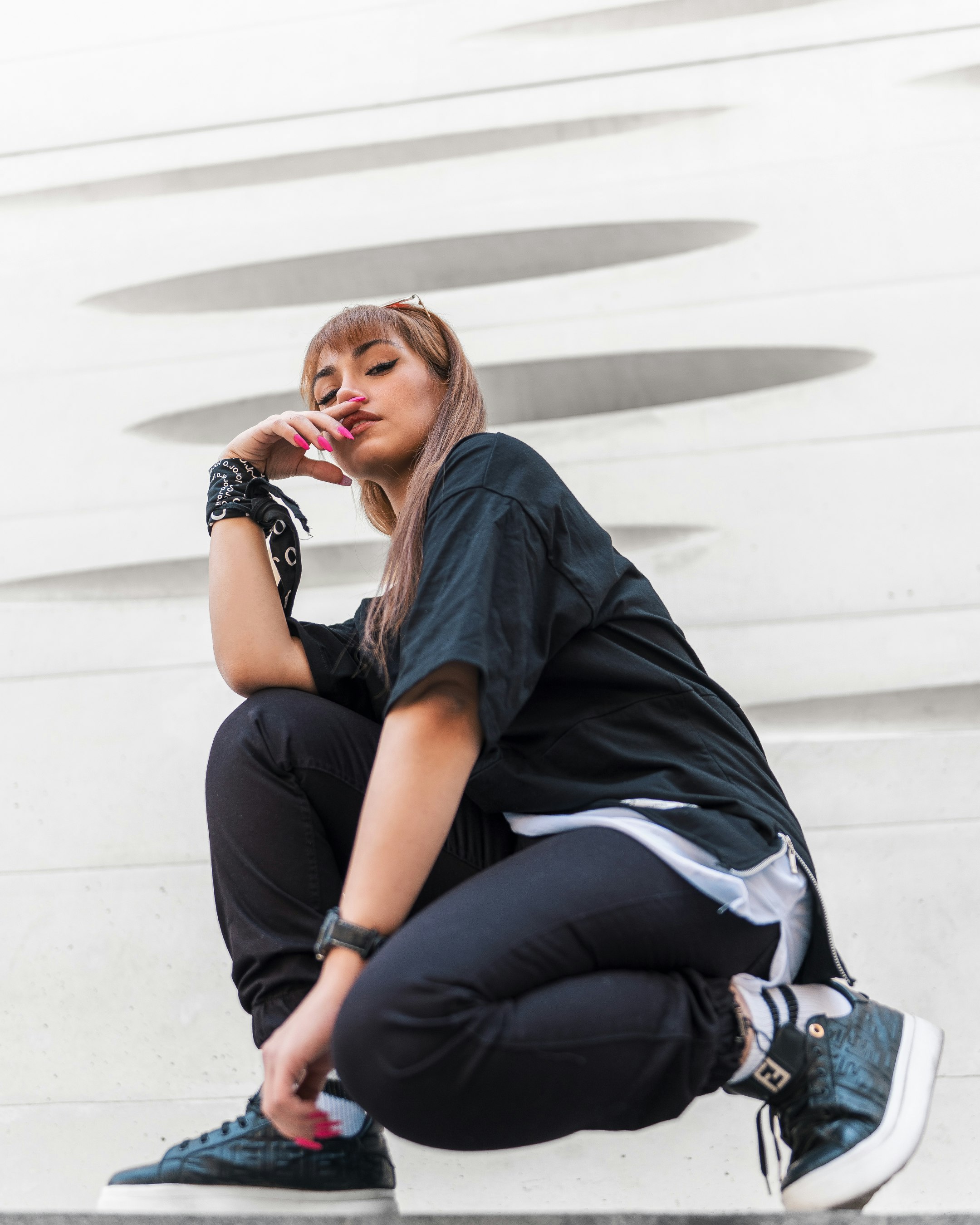 woman in black shirt and blue denim jeans sitting on white concrete stairs